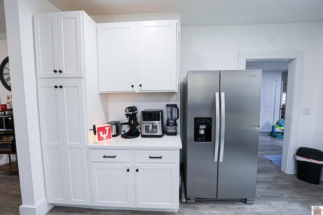 kitchen with stainless steel fridge with ice dispenser, white cabinets, and light hardwood / wood-style floors