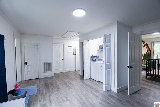 laundry room featuring hardwood / wood-style floors, washer and dryer, and crown molding