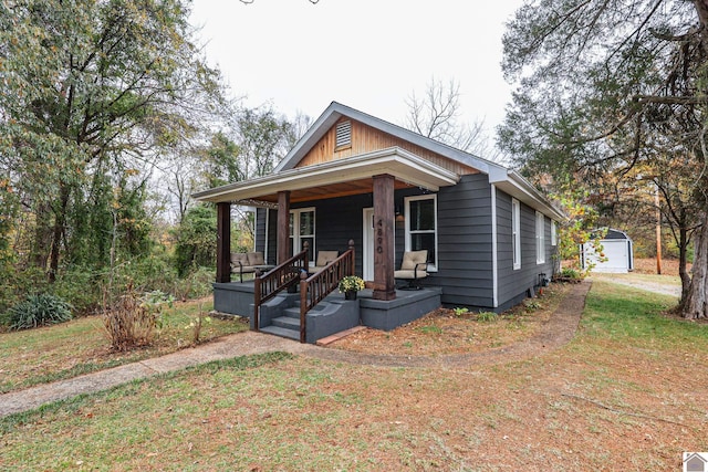 bungalow with an outbuilding, a front lawn, a porch, and a garage