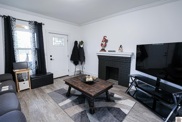 living room featuring crown molding, light hardwood / wood-style flooring, and a brick fireplace