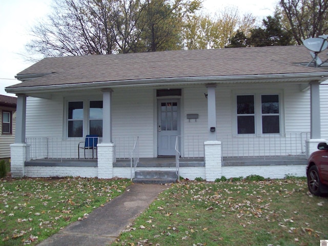 bungalow-style home featuring covered porch and a front yard