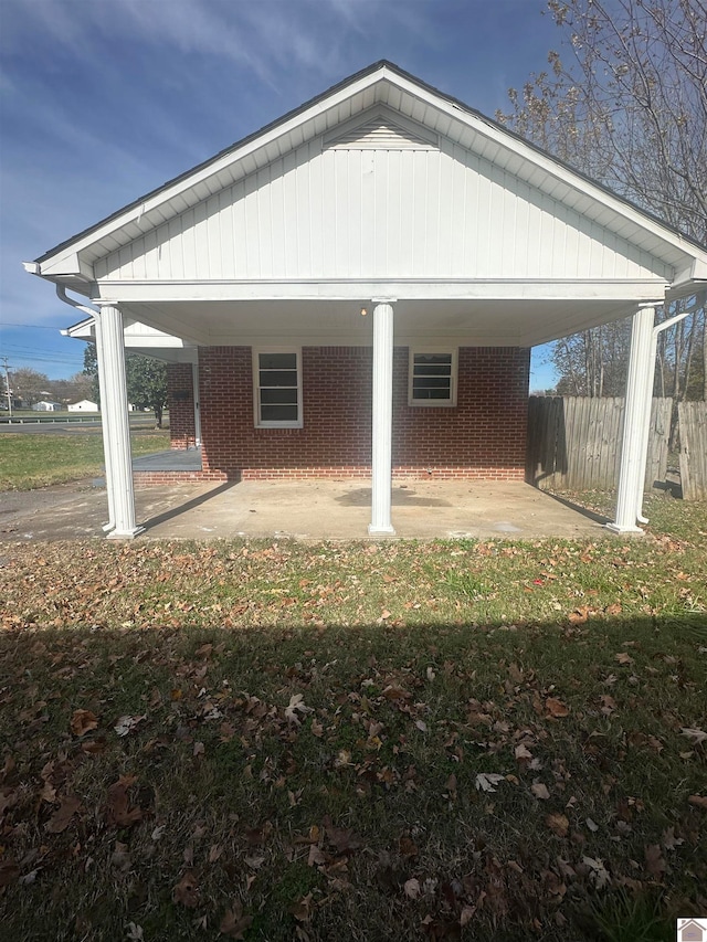 back of house featuring a carport and a yard