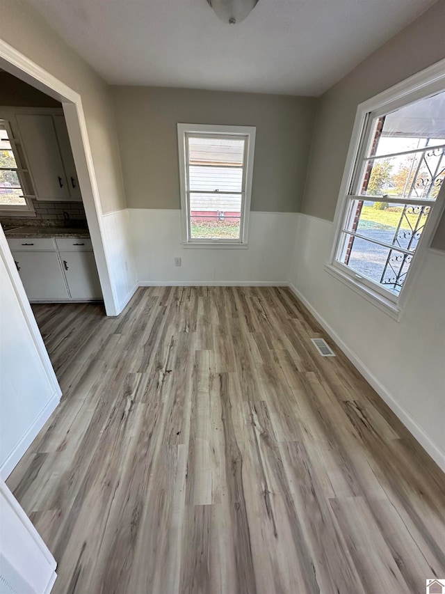 unfurnished dining area featuring light wood-type flooring