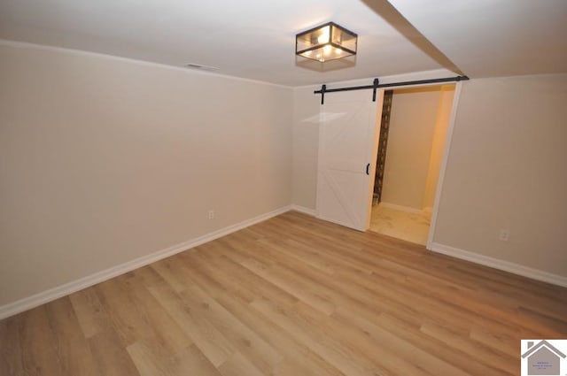 spare room with wood-type flooring and a barn door