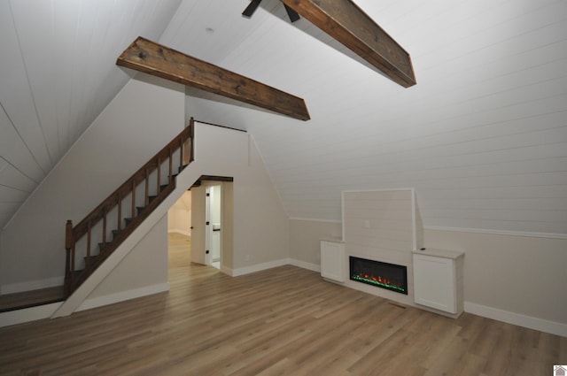 unfurnished living room featuring hardwood / wood-style flooring, vaulted ceiling with beams, and wooden ceiling