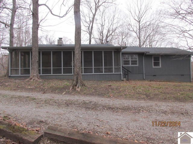 rear view of property featuring a sunroom