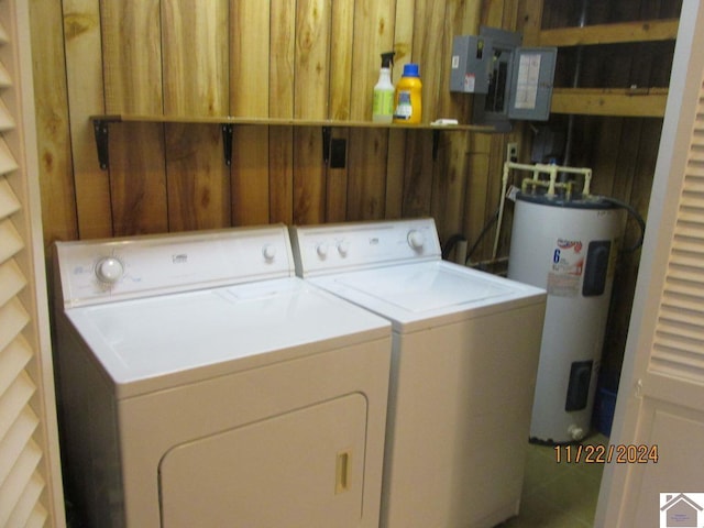 laundry area with independent washer and dryer, electric water heater, and wooden walls