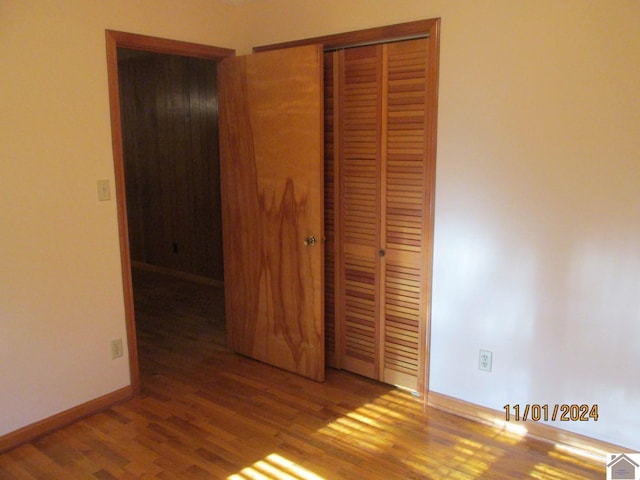 unfurnished bedroom with hardwood / wood-style flooring and a closet