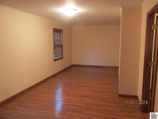 unfurnished room with hardwood / wood-style flooring and crown molding