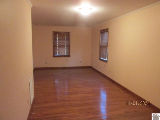 unfurnished room with wood-type flooring and ornamental molding