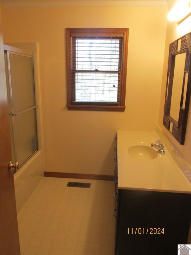 bathroom featuring tile patterned floors, vanity, and combined bath / shower with glass door