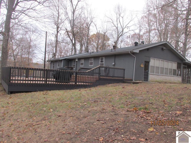 rear view of property with a sunroom and a wooden deck