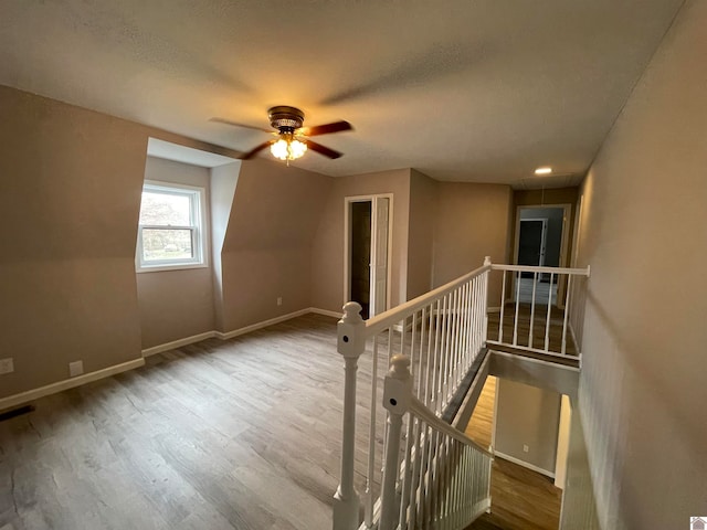 bonus room with ceiling fan, wood-type flooring, and a textured ceiling