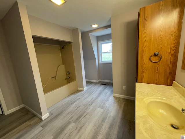 bathroom with vanity, wood-type flooring, and  shower combination