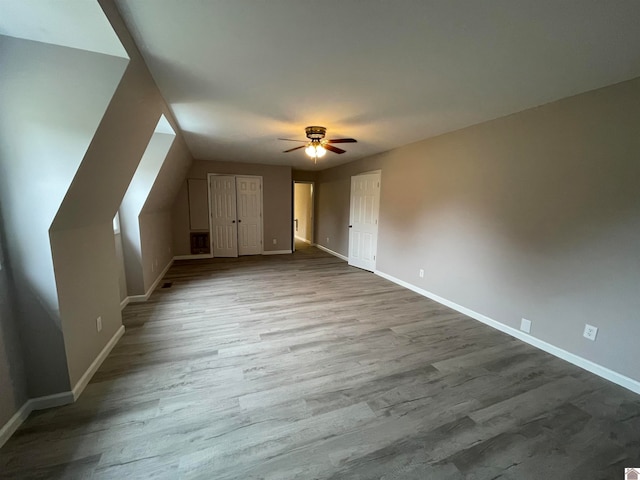 additional living space with ceiling fan, light wood-type flooring, and lofted ceiling