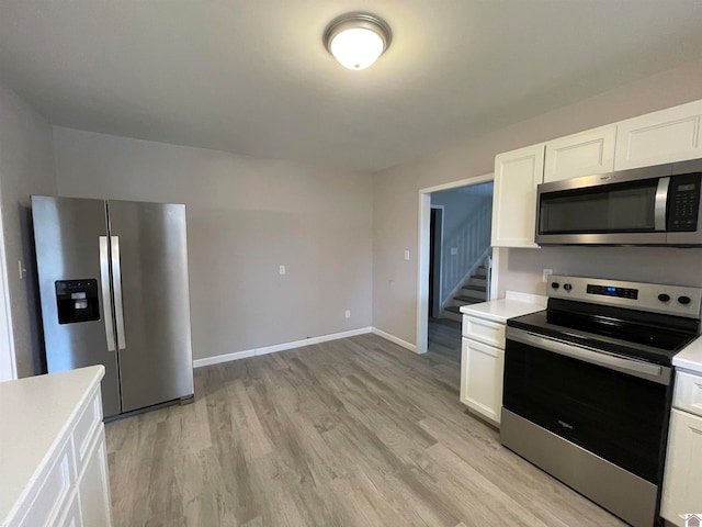 kitchen with white cabinets, light hardwood / wood-style floors, and appliances with stainless steel finishes