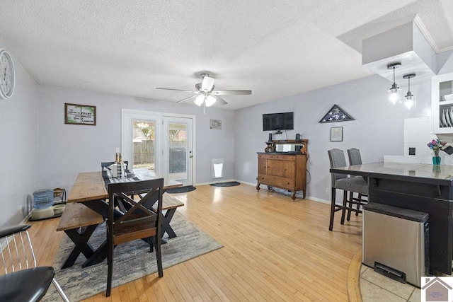 dining area featuring ceiling fan, a textured ceiling, and light wood-type flooring