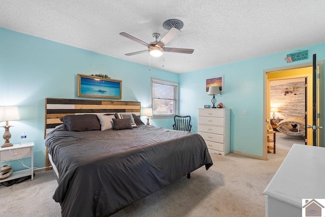 carpeted bedroom featuring ceiling fan and a textured ceiling