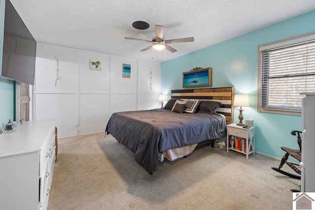 carpeted bedroom with ceiling fan and a textured ceiling