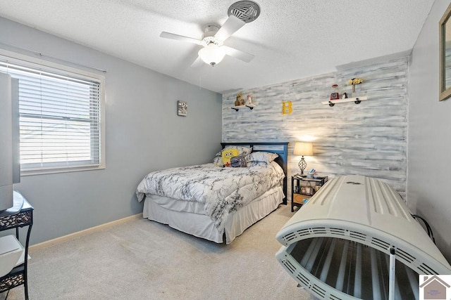 carpeted bedroom with ceiling fan and a textured ceiling