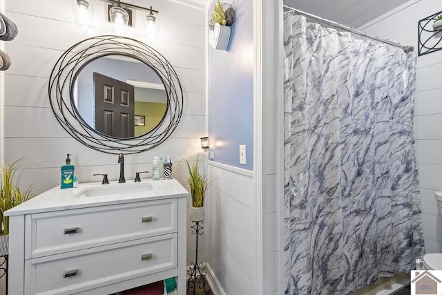 bathroom with a shower with curtain, tile walls, and vanity