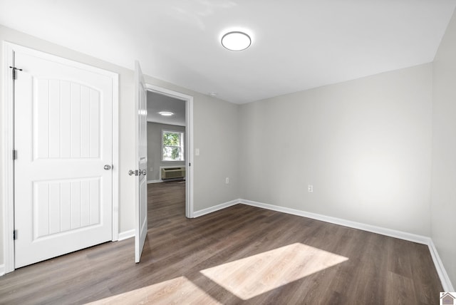 spare room featuring hardwood / wood-style floors and a wall mounted AC