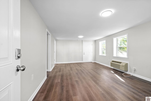 interior space featuring dark hardwood / wood-style flooring and a wall unit AC