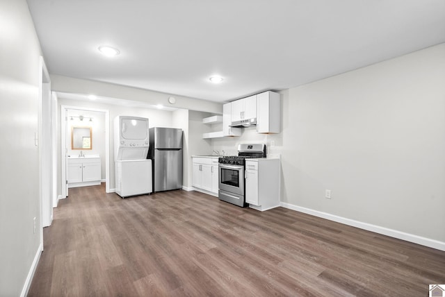 kitchen with stacked washer and dryer, white cabinets, light hardwood / wood-style floors, and appliances with stainless steel finishes