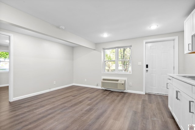 interior space featuring a wall mounted air conditioner and dark wood-type flooring