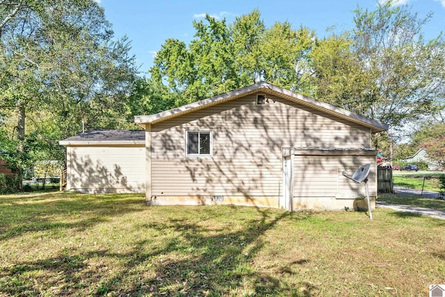 view of side of home with a yard