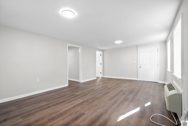 interior space featuring a wall mounted air conditioner and dark hardwood / wood-style floors