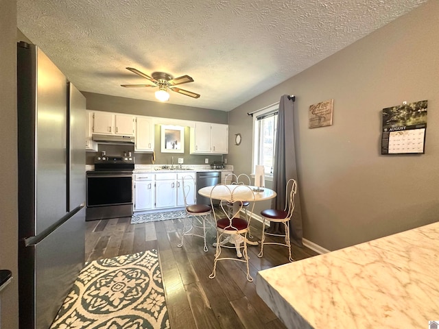 kitchen with a textured ceiling, stainless steel appliances, ceiling fan, white cabinets, and dark hardwood / wood-style floors