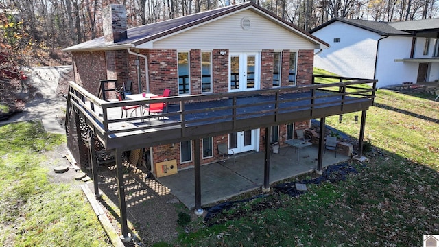 rear view of house featuring a lawn, a patio area, a deck, and french doors