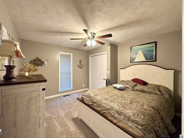 bedroom with carpet, ceiling fan, and a textured ceiling