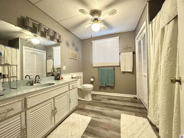 bathroom featuring hardwood / wood-style flooring, vanity, ceiling fan, and toilet