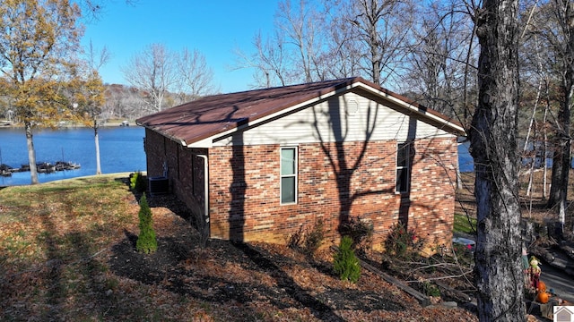 view of home's exterior with cooling unit and a water view