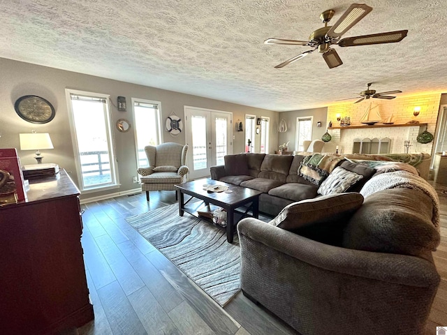 living room with dark hardwood / wood-style floors, ceiling fan, a textured ceiling, and french doors