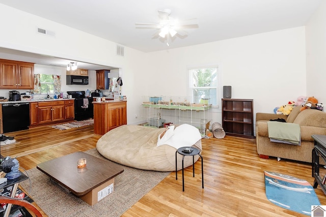 living room featuring plenty of natural light, ceiling fan, sink, and light hardwood / wood-style flooring