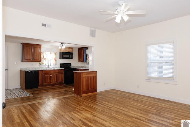 kitchen with sink, ceiling fan, dark wood-type flooring, and black appliances