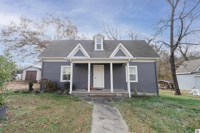 view of front facade featuring a garage, covered porch, an outdoor structure, and a front yard