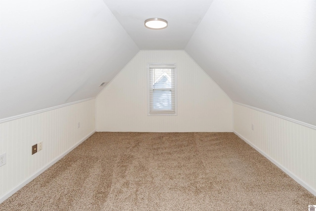 additional living space featuring carpet floors and vaulted ceiling