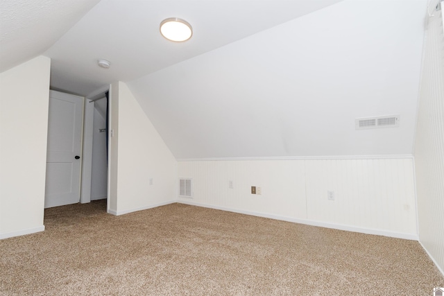 bonus room with carpet floors and vaulted ceiling