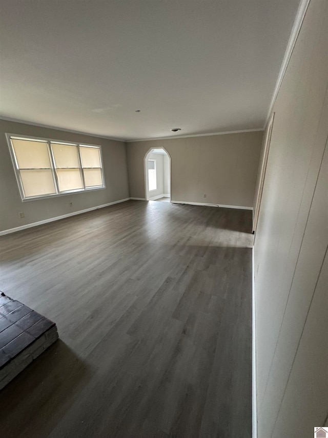 spare room featuring crown molding and dark wood-type flooring