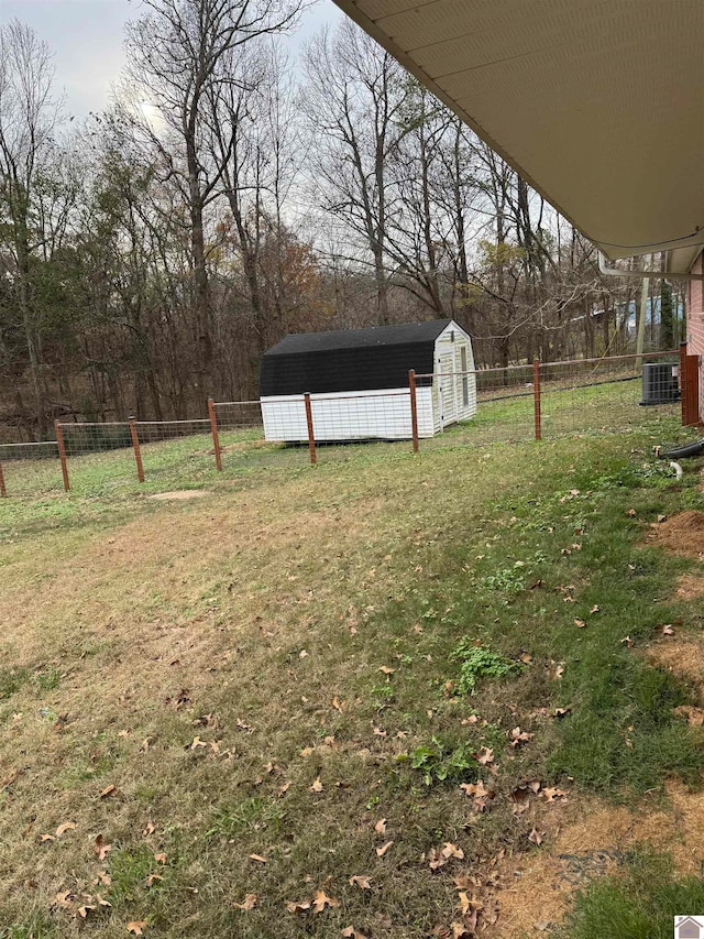 view of yard with central AC and a storage shed