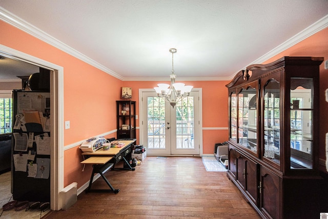 dining area featuring wood-type flooring, ornamental molding, a wealth of natural light, and french doors