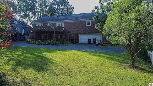 back of house with a lawn, a deck, and a garage