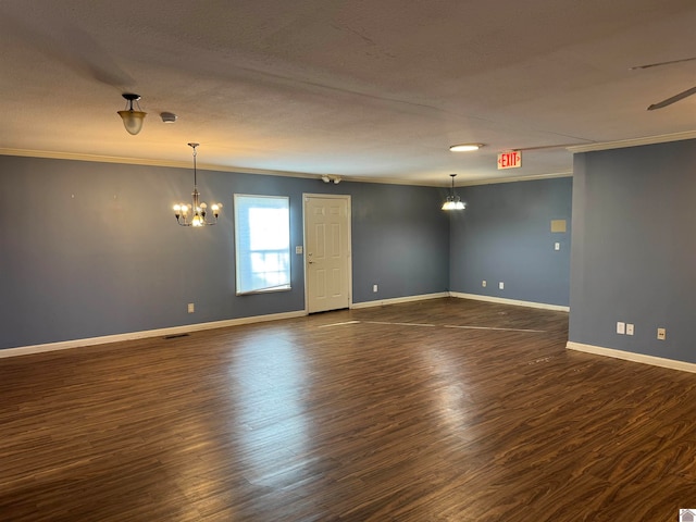 empty room featuring a textured ceiling, dark hardwood / wood-style flooring, and ornamental molding