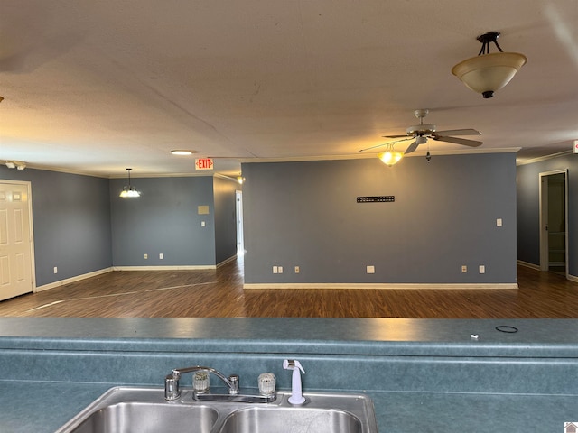 kitchen featuring ornamental molding, ceiling fan, dark wood-type flooring, and sink