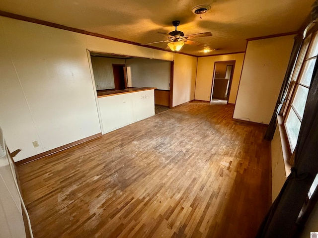 empty room with hardwood / wood-style flooring, ceiling fan, crown molding, and a textured ceiling