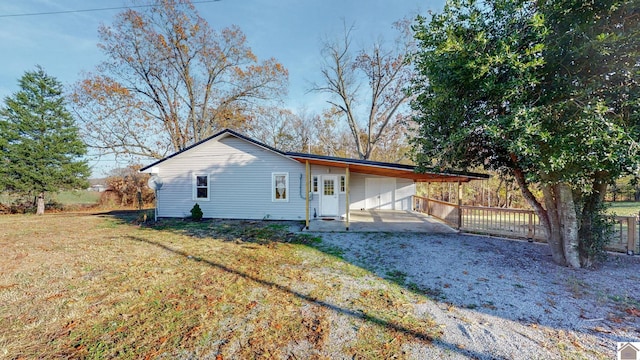 view of side of home with a carport and a lawn